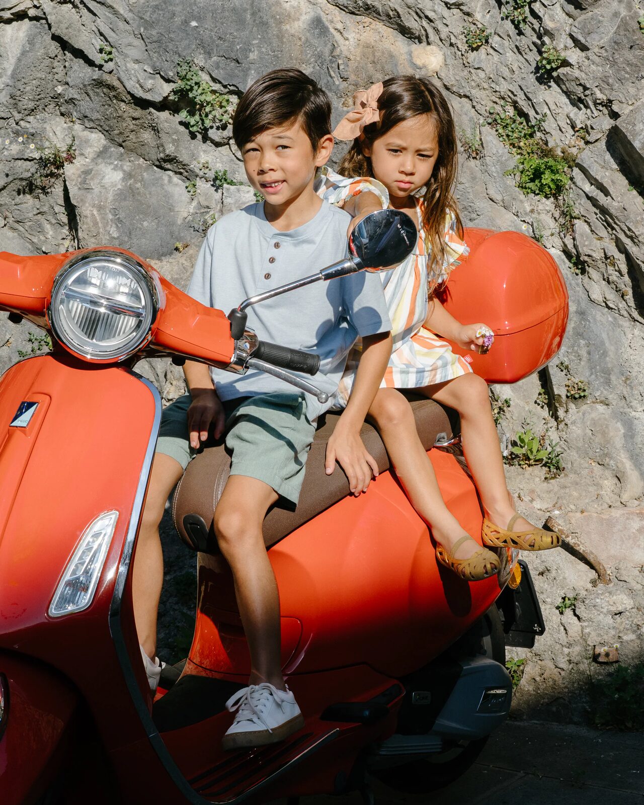 Family riding a bright red scooter